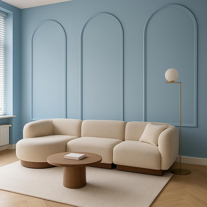 Lichte Japandi woonkamer met blauwe muur, crème hoekbank en subtiele sierlijsten in ronde vorm