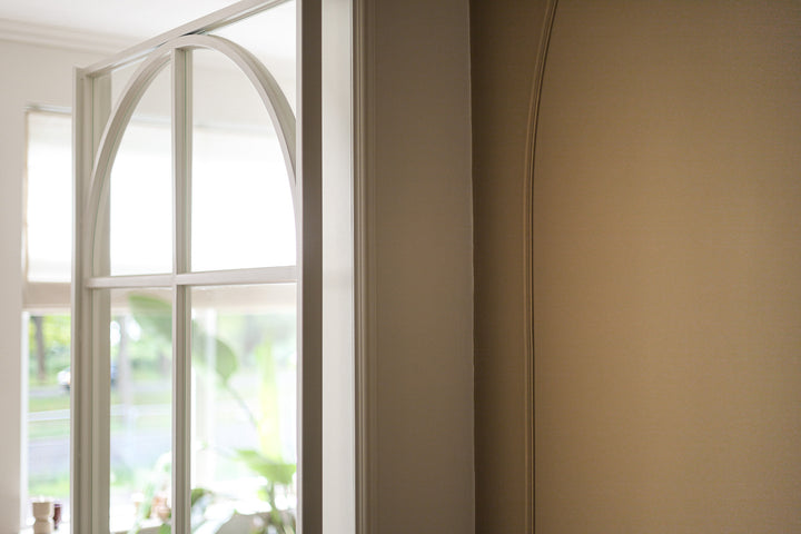 Flexlijst Crown naast glazen deur met metalen details en een boog